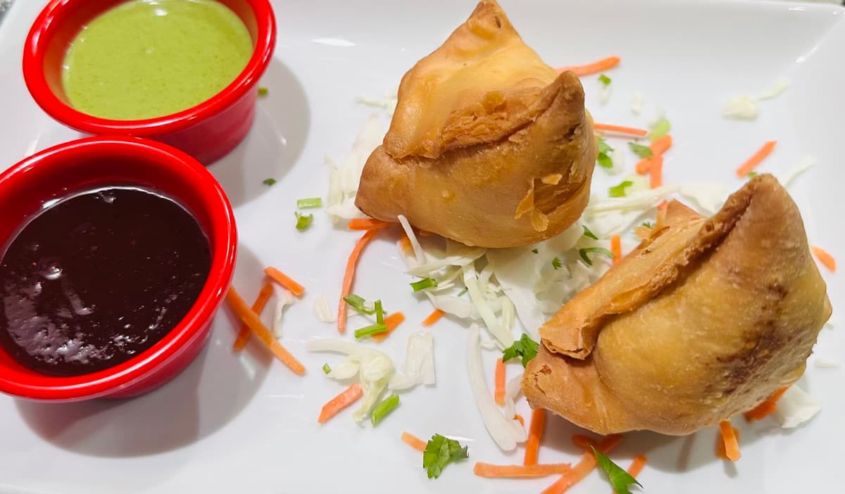 Crispy samosas with green chutney and tamarind